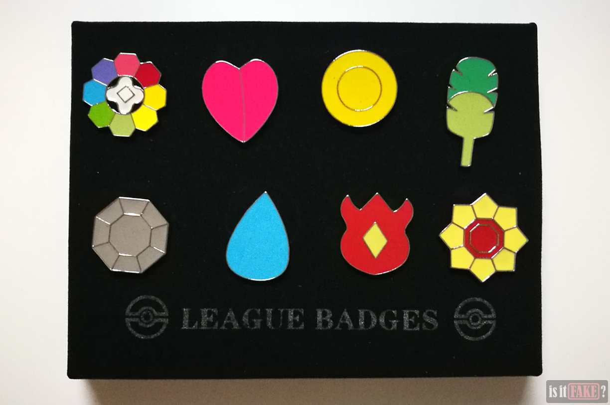 Fake Pokemon badges hanging from cardboard insert